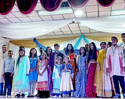 A group of people standing on a stage after participating in a cultural event