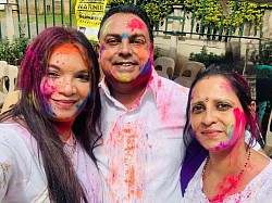 3 people with coloured powder smeared on their faces