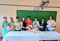 Group of knitters with knitted knockers for cancer patients