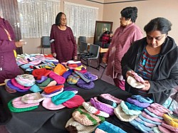 Women around a table of knitted items