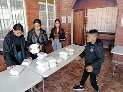 A group of children stacking polystyrene containers on a table