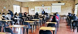 Children and adults in a classroom with chairs and desks