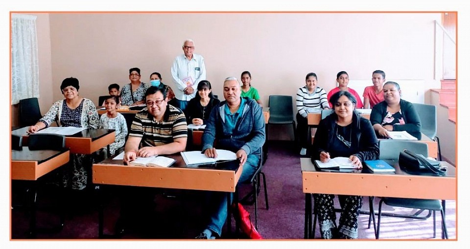 Children and adults sitting in a classroom